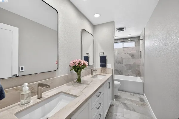 a bathroom with a granite countertop sink and a mirror