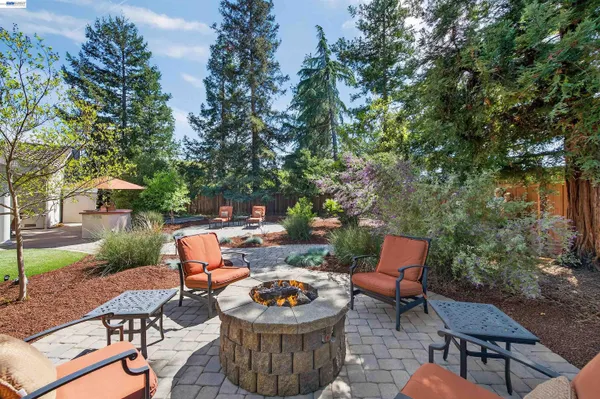 a backyard of a house with fire pit and outdoor seating