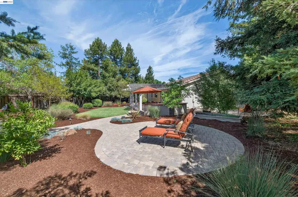 an outdoor sitting area with furniture and garden