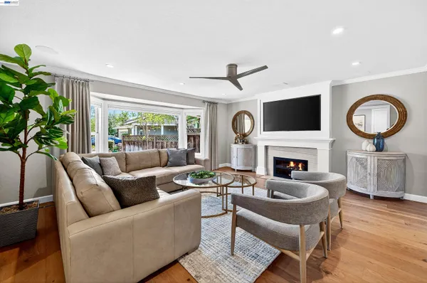 a living room with furniture a fireplace a flat screen tv and a large window