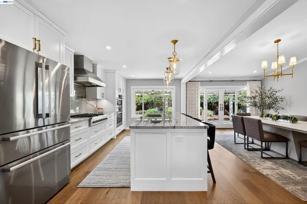 a kitchen with kitchen island a large counter top space a sink appliances and cabinets