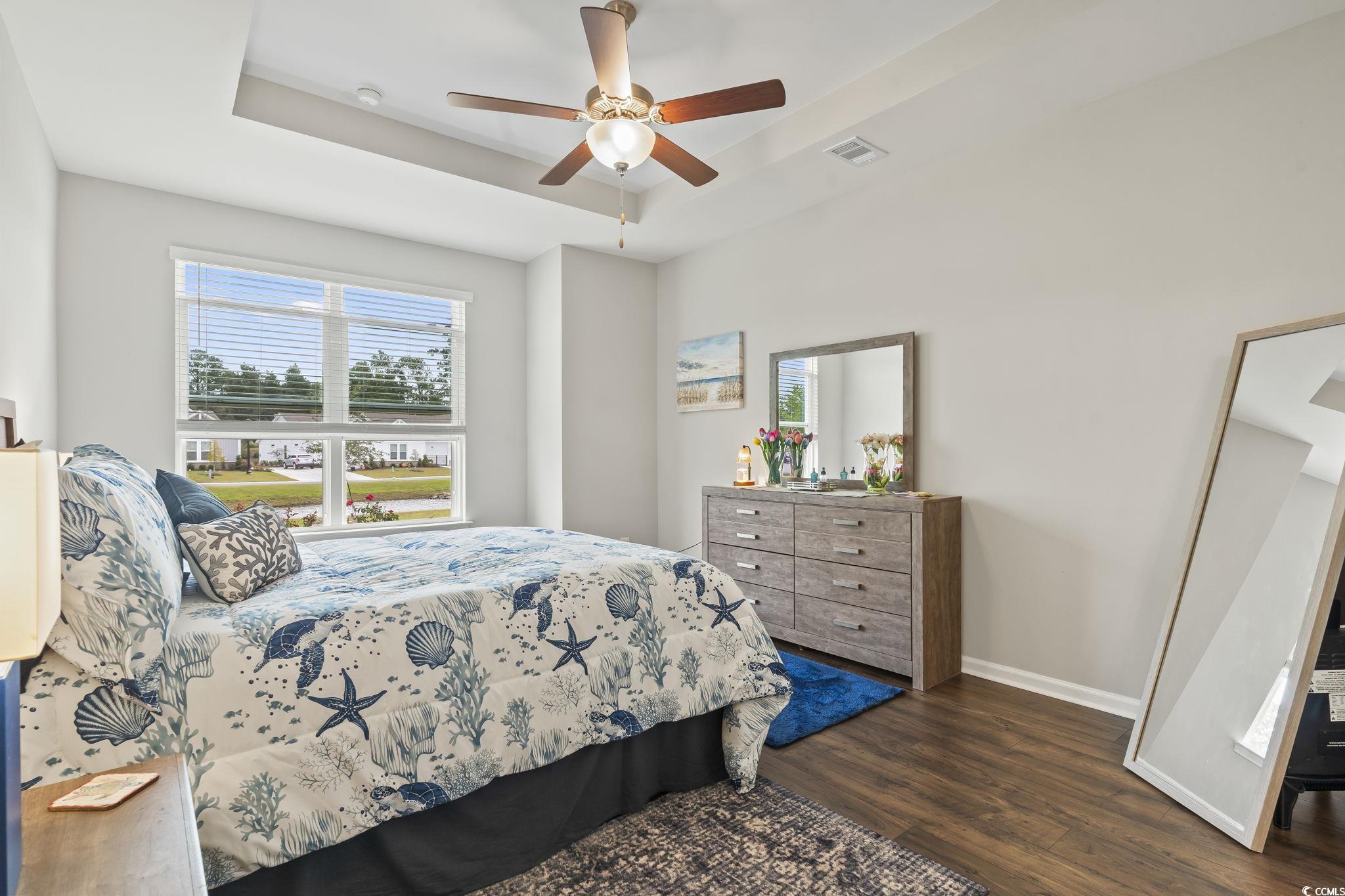 4040 Taranto Loop, Unit 5303C Myrtle Beach, SC 29579 - Photo 23 of 38 Bedroom featuring a tray ceiling, multiple windows, dark wood finished floors, and ceiling fan