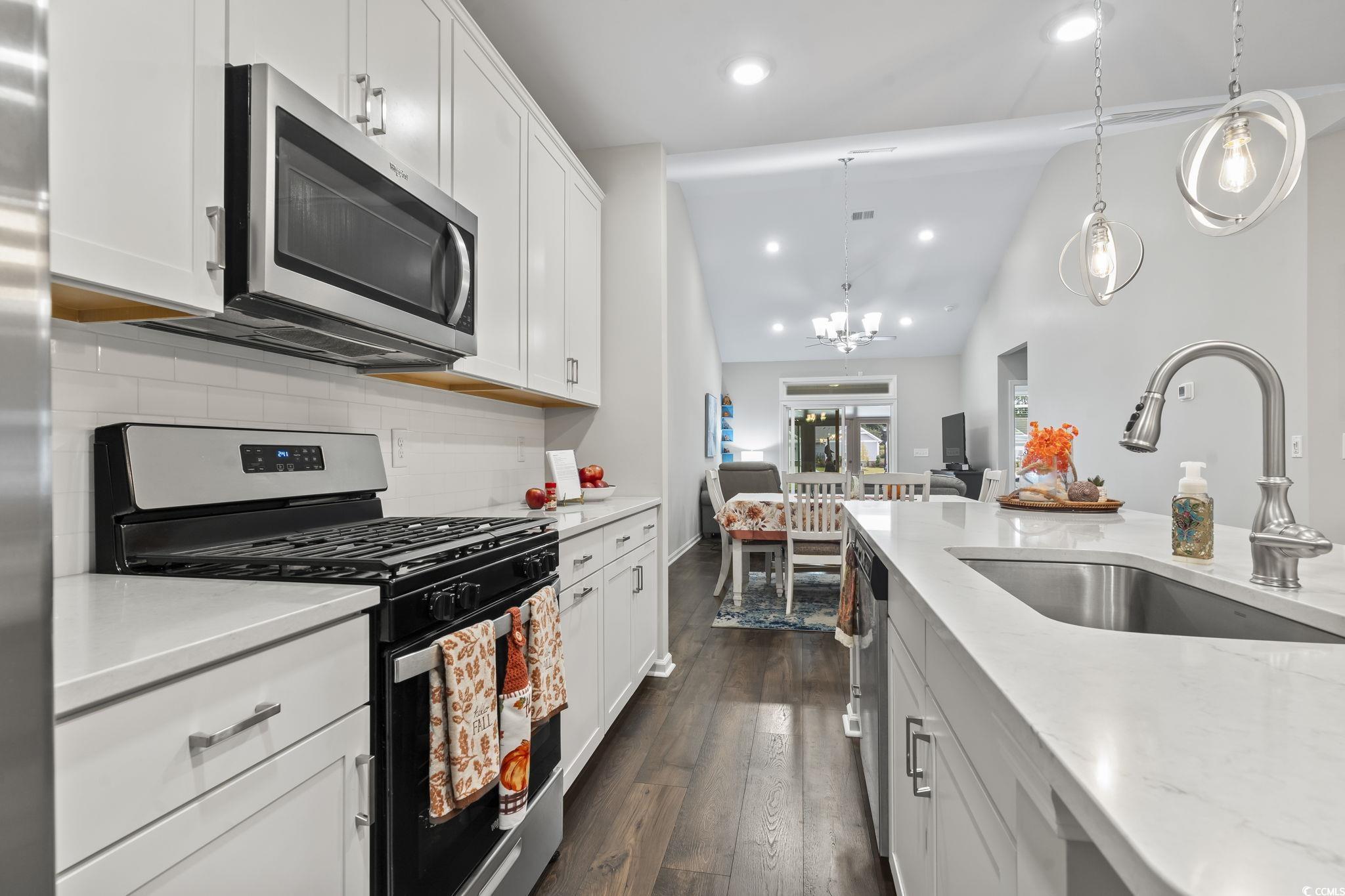 4040 Taranto Loop, Unit 5303C Myrtle Beach, SC 29579 - Photo 7 of 38 Kitchen featuring appliances with stainless steel finishes, lofted ceiling, recessed lighting, white cabinets, and dark wood finished floors