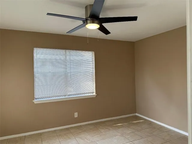 an empty room with a window and a fan