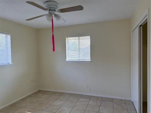 en empty room with windows and fan