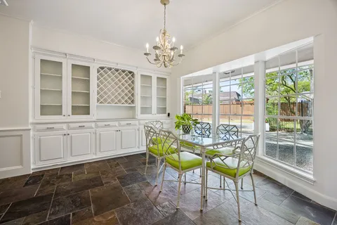 a dining room with furniture a chandelier and wooden floor