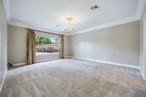 a view of a hallway with front door wooden floor and a chandelier