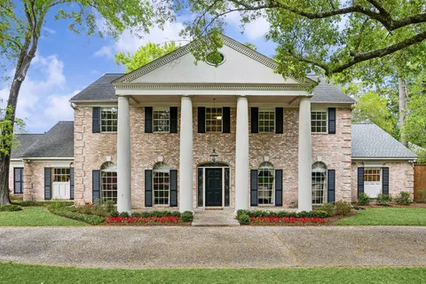 front view of a brick house with a yard