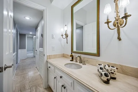 a bathroom with a granite countertop sink and a mirror