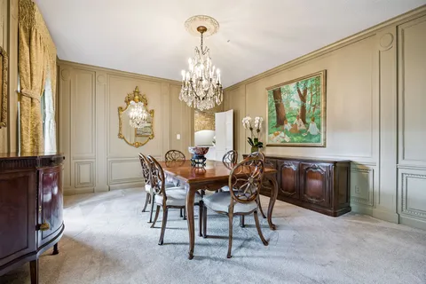 a view of a dining room with furniture and chandelier