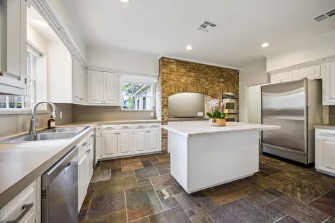 a kitchen with stainless steel appliances a refrigerator sink and stove