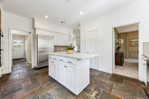 a kitchen with stainless steel appliances granite countertop a refrigerator and a stove top oven