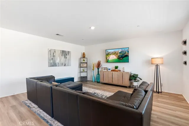 a living room with furniture and a wooden floor