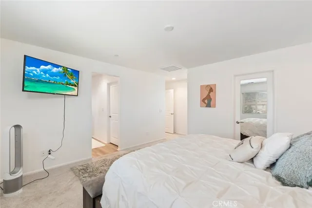 a bedroom with a bed and a painting on the wall