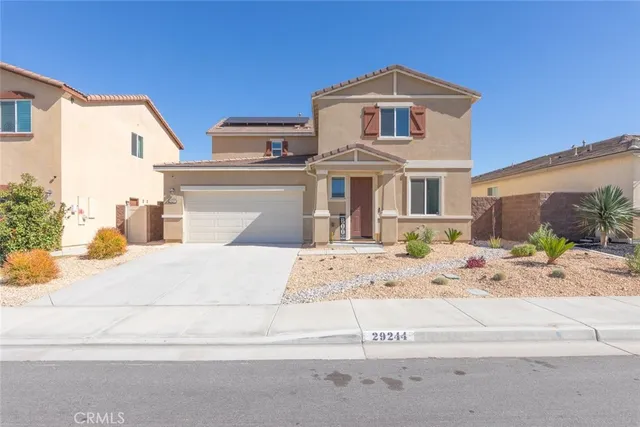 a front view of a house with a dirt road and a building