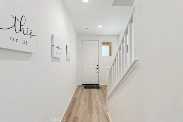 a view of a hallway with wooden floor and entryway