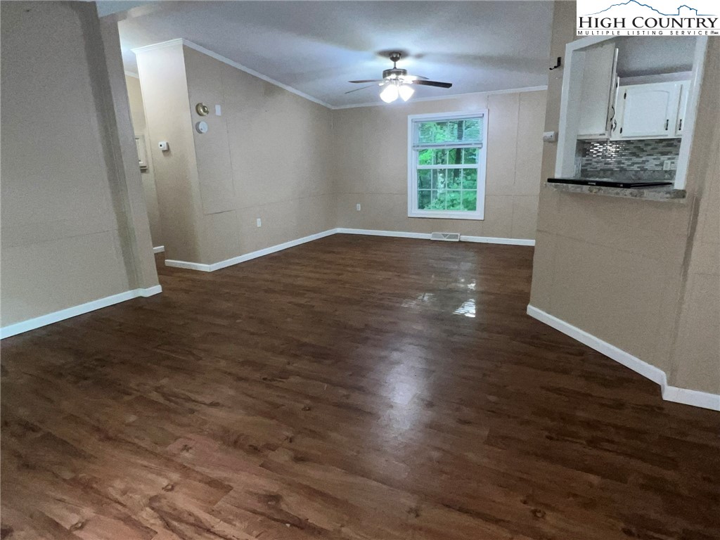 1980 Mountaindale Road Vilas, NC 28692 - Photo 12 of 25 an empty room with wooden floor cabinet and windows