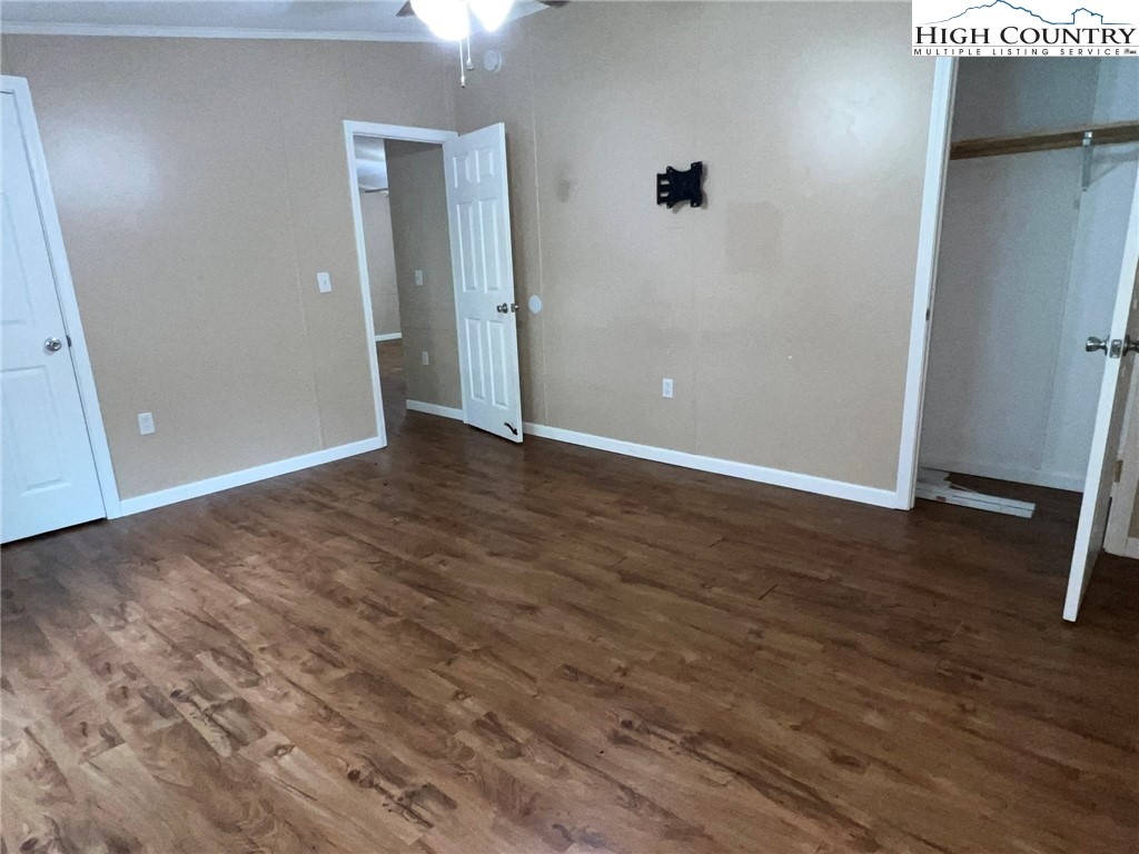 1980 Mountaindale Road Vilas, NC 28692 - Photo 15 of 25 an empty room with wooden floor and windows