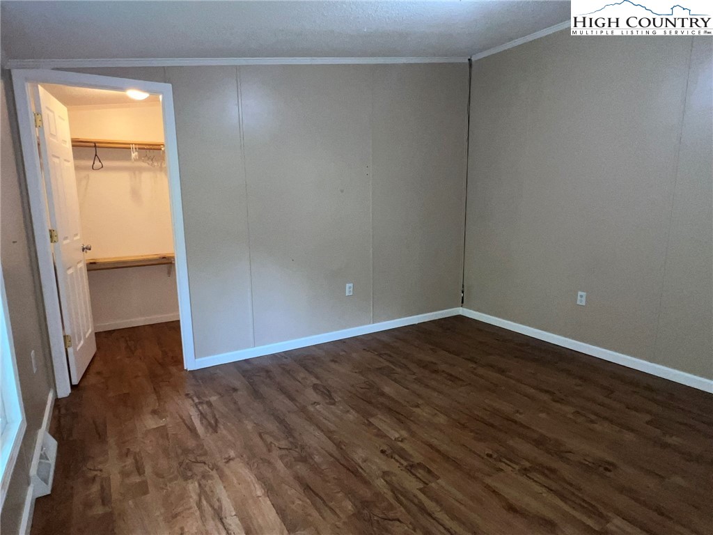 1980 Mountaindale Road Vilas, NC 28692 - Photo 20 of 25 a view of an empty room with wooden floor and a window