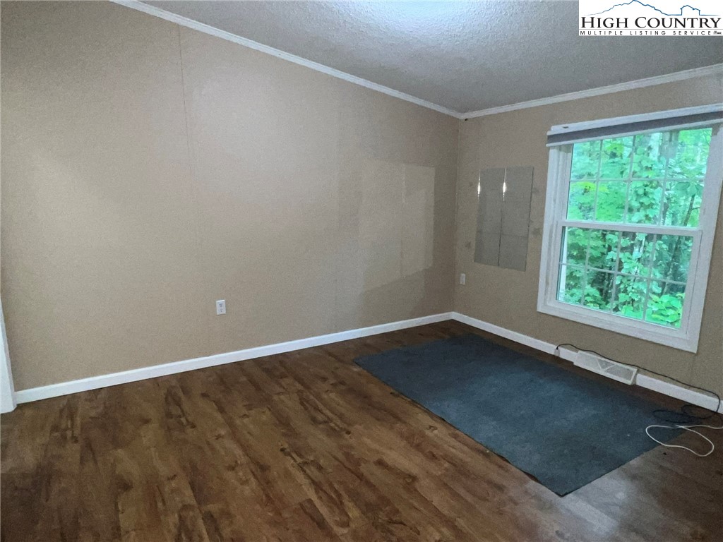 1980 Mountaindale Road Vilas, NC 28692 - Photo 22 of 25 a view of an empty room with wooden floor and a window