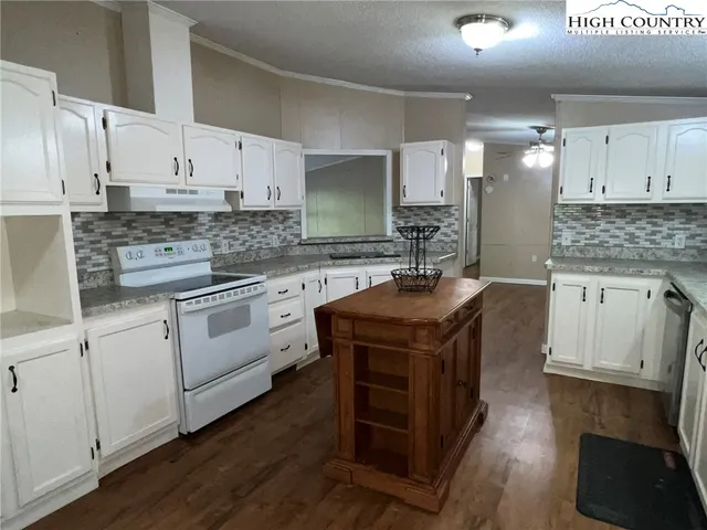 a kitchen with a stove sink and cabinets