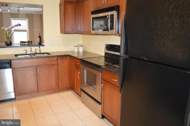 a kitchen with stainless steel appliances granite countertop a sink stove and cabinets