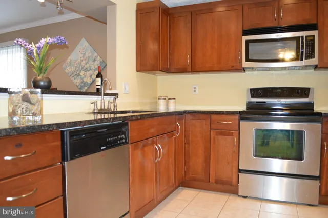 a kitchen with stainless steel appliances granite countertop a stove and a microwave