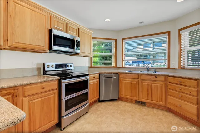 a kitchen with stainless steel appliances granite countertop a stove microwave and sink