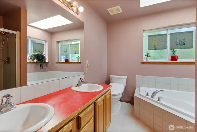 a bathroom with a tub sink and mirror