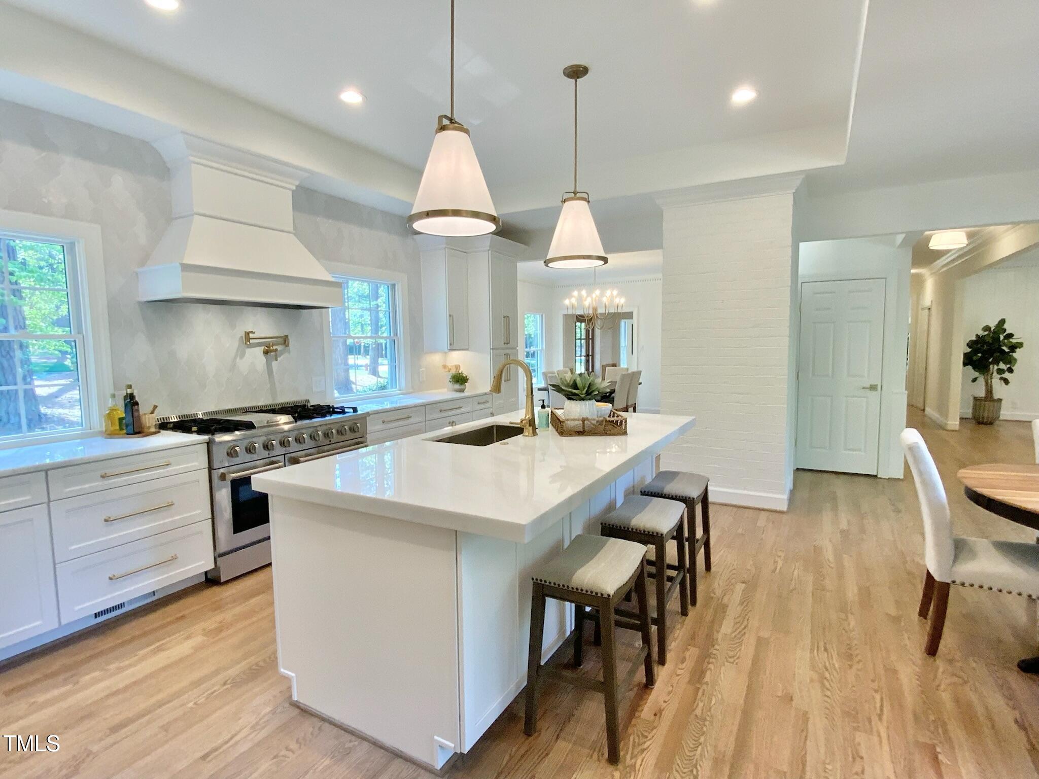 3838 Regent Road Durham, NC 27707 - Photo 18 of 55 a kitchen with a table chairs refrigerator and cabinets