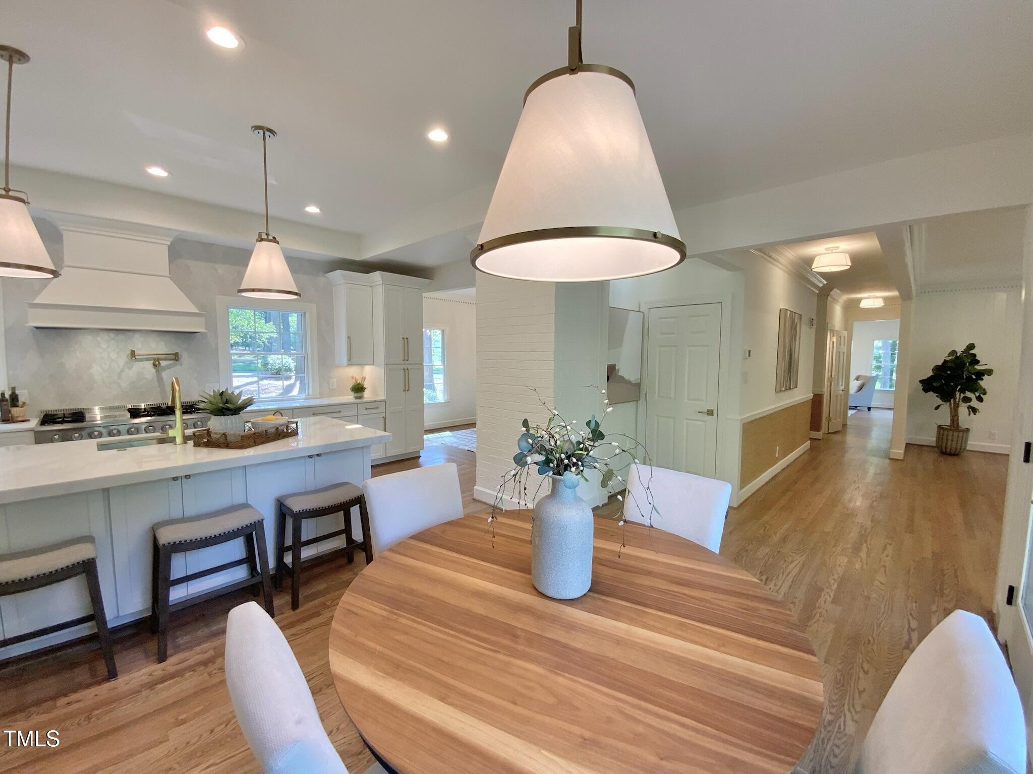 3838 Regent Road Durham, NC 27707 - Photo 20 of 55 a view of a dining room and livingroom with furniture wooden floor a chandelier
