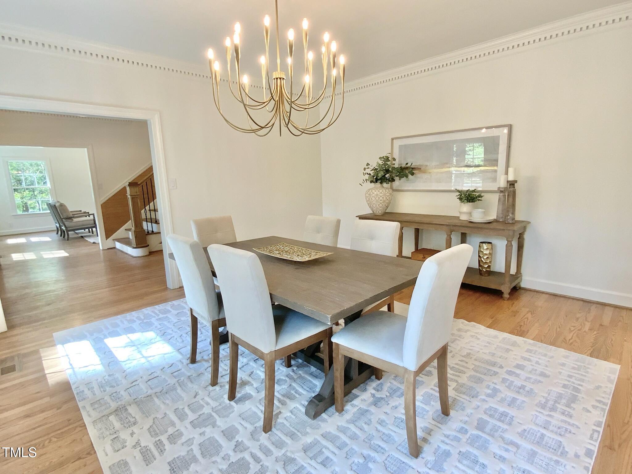 3838 Regent Road Durham, NC 27707 - Photo 23 of 55 a view of a dining room with furniture a chandelier and wooden floor