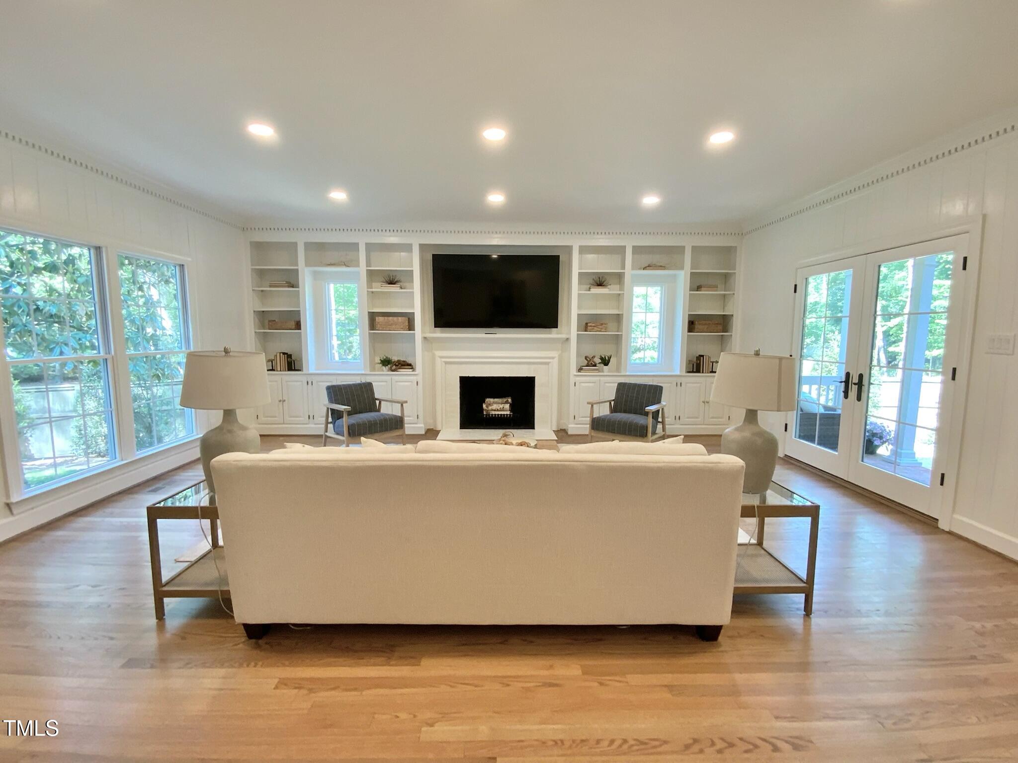 3838 Regent Road Durham, NC 27707 - Photo 25 of 55 a living room with furniture a flat screen tv and a fireplace