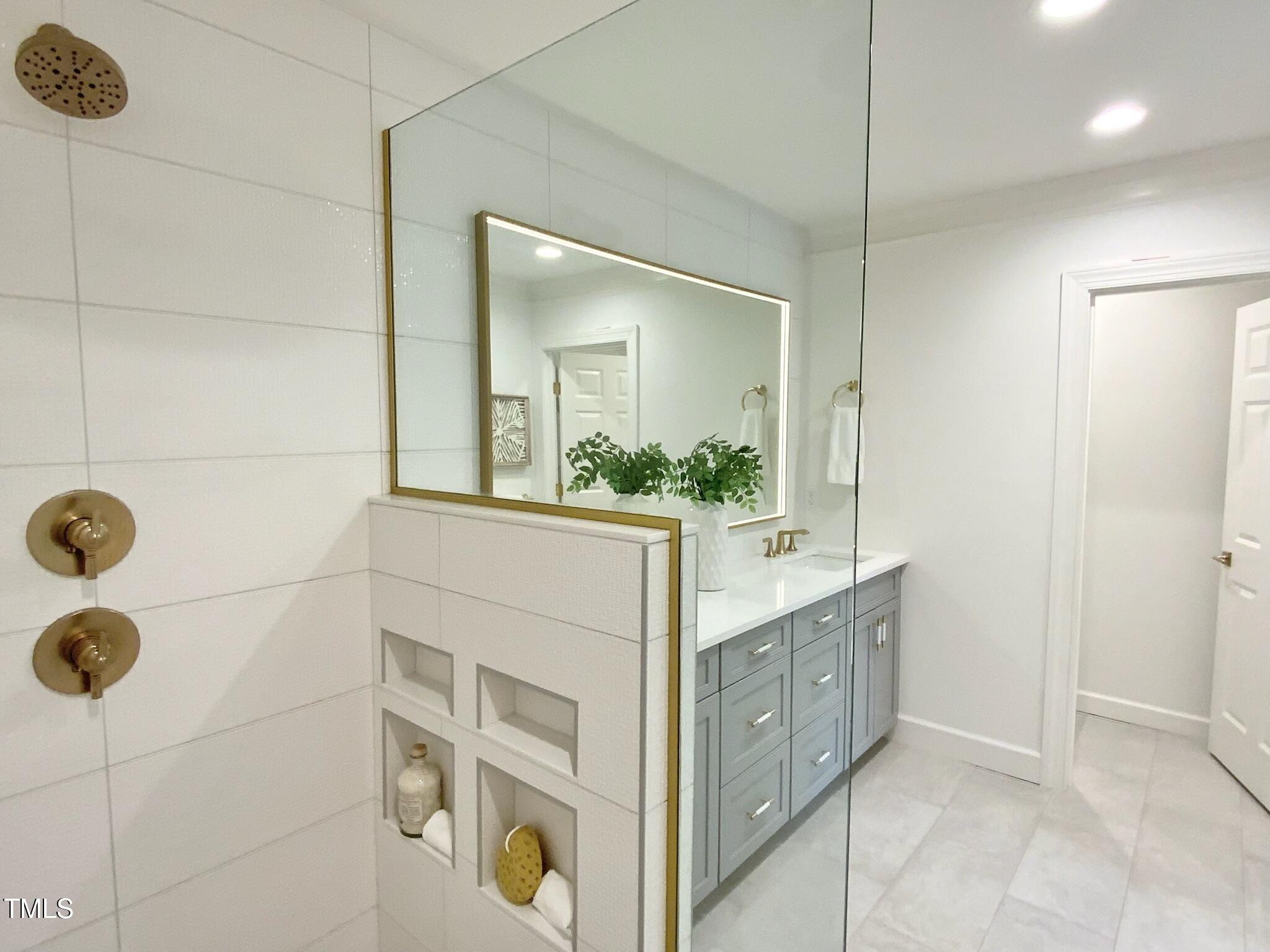 3838 Regent Road Durham, NC 27707 - Photo 37 of 55 a bathroom with a double vanity sink a mirror and shower