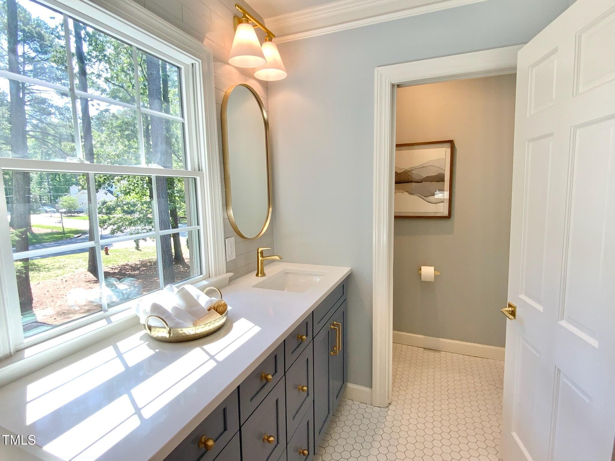 3838 Regent Road Durham, NC 27707 - Photo 44 of 55 a bathroom with a granite countertop sink and a mirror
