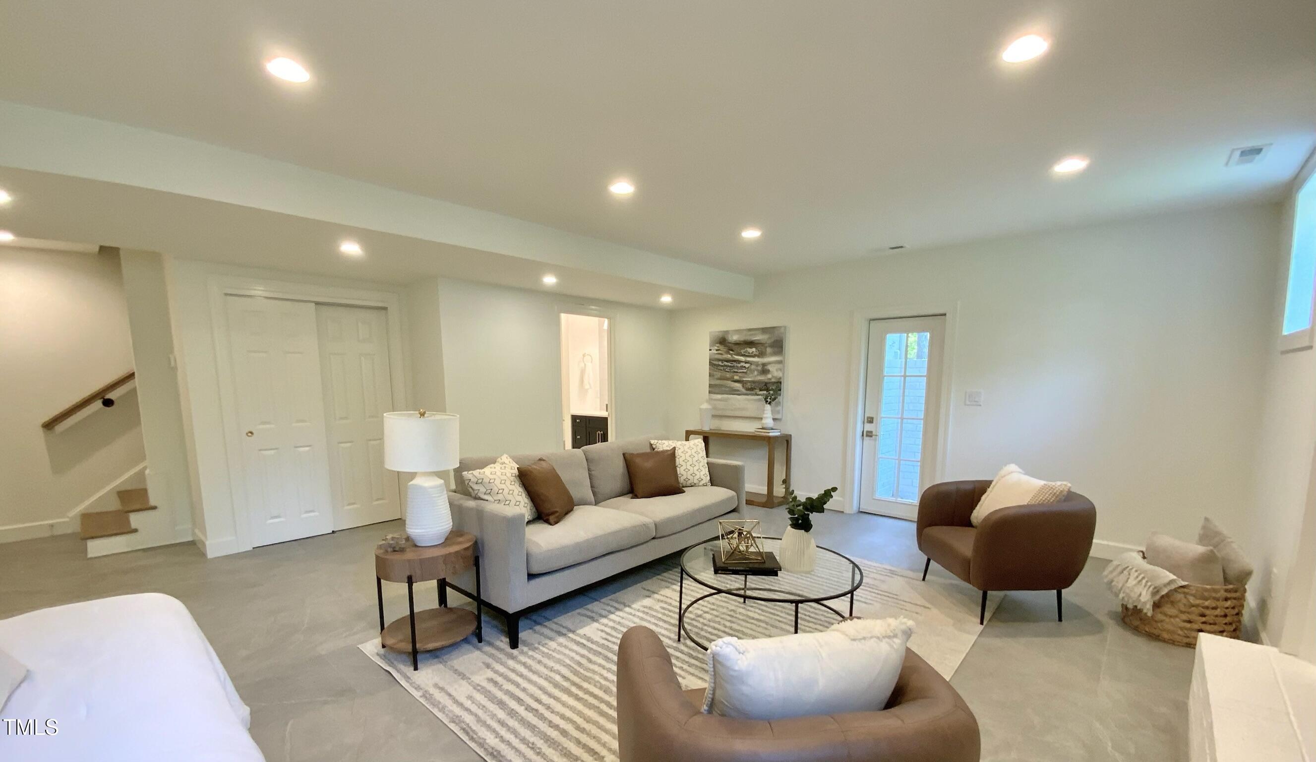 3838 Regent Road Durham, NC 27707 - Photo 48 of 55 a living room with furniture a rug and a large mirror