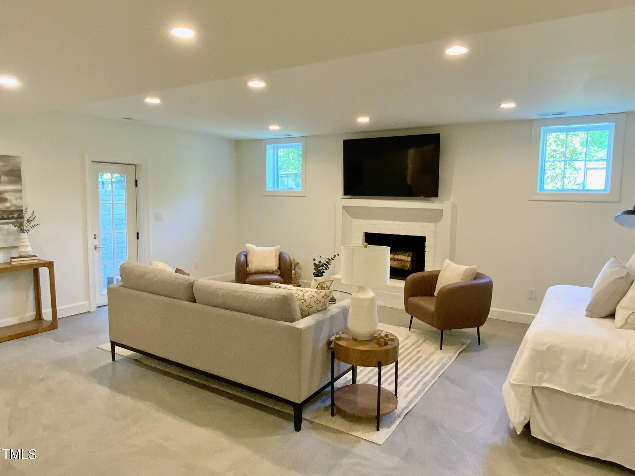 3838 Regent Road Durham, NC 27707 - Photo 49 of 55 a living room with furniture a flat screen tv and a fireplace
