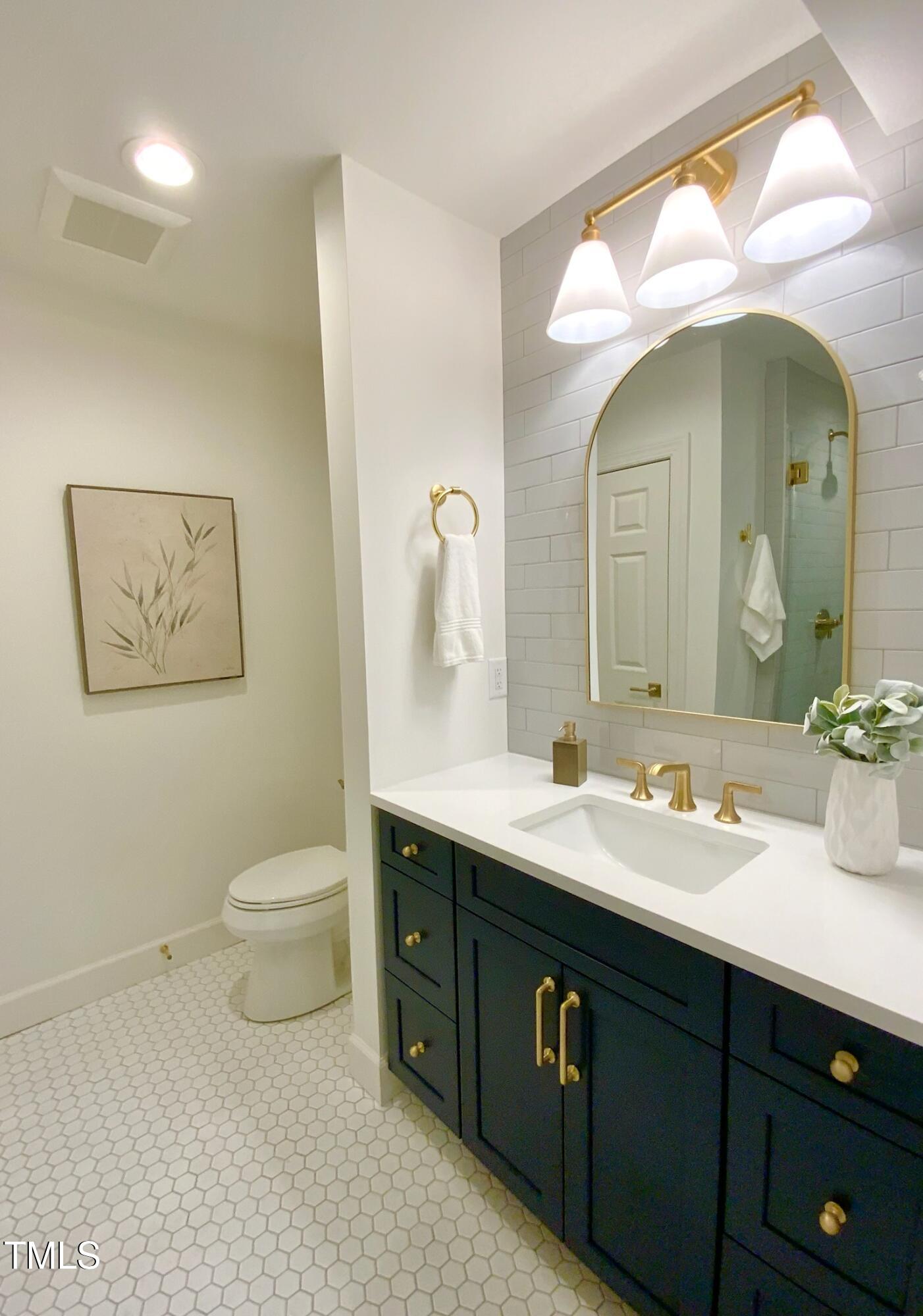 3838 Regent Road Durham, NC 27707 - Photo 50 of 55 a bathroom with a double vanity sink and a mirror