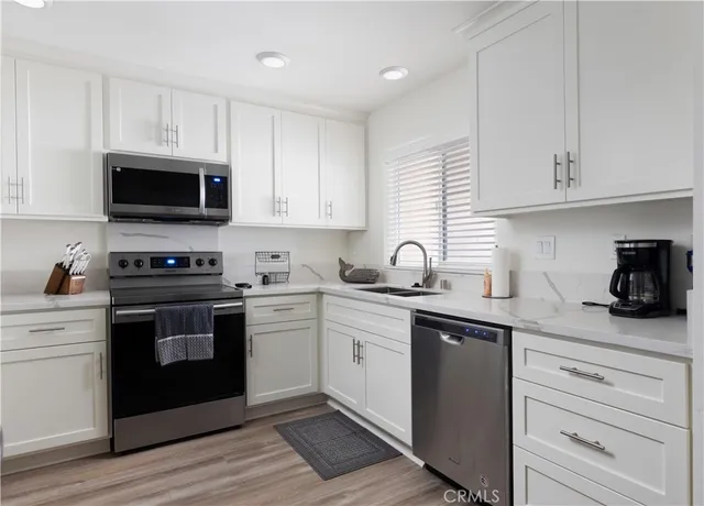 a kitchen with cabinets stainless steel appliances and a sink