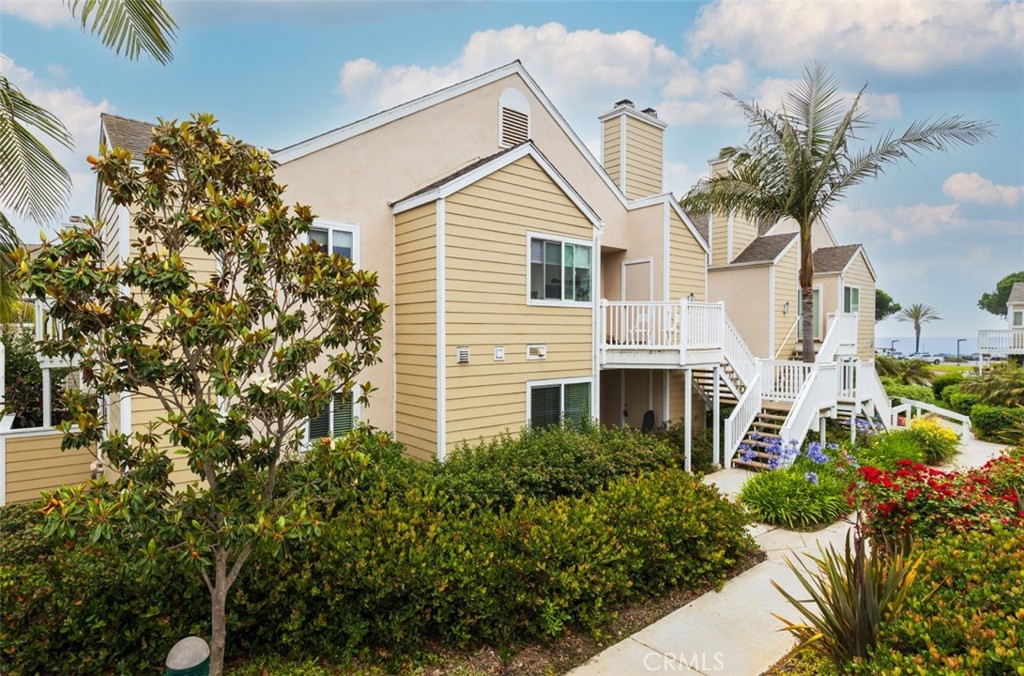34116 Selva Road, Unit 308 Dana Point, CA 92629 - Photo 3 of 29 a view of a white house next to a yard with potted plants