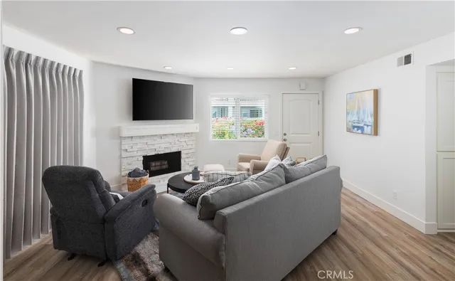 a living room with furniture a flat screen tv and a fireplace