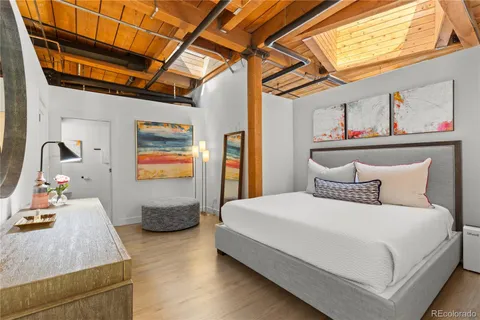 a bedroom with a bed and wooden floor