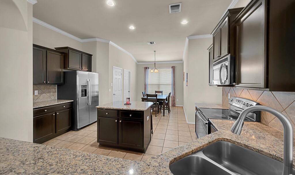 9801 Shallow Creek Drive Waco, TX 76708 - Photo 11 of 31 a kitchen with stainless steel appliances granite countertop a sink a stove and a refrigerator