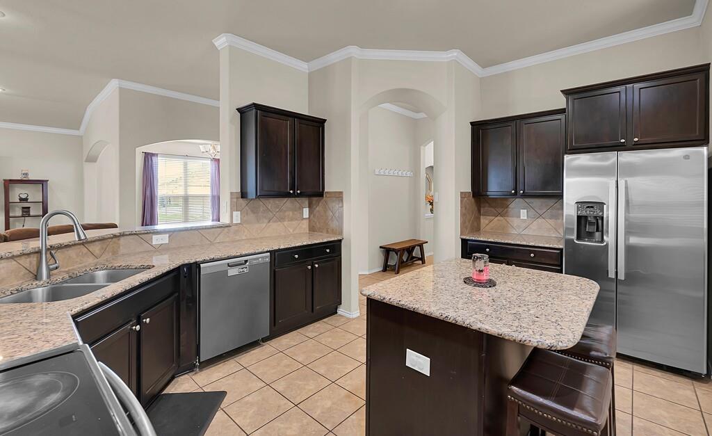 9801 Shallow Creek Drive Waco, TX 76708 - Photo 14 of 31 a kitchen with a sink a kitchen island and stainless steel appliances