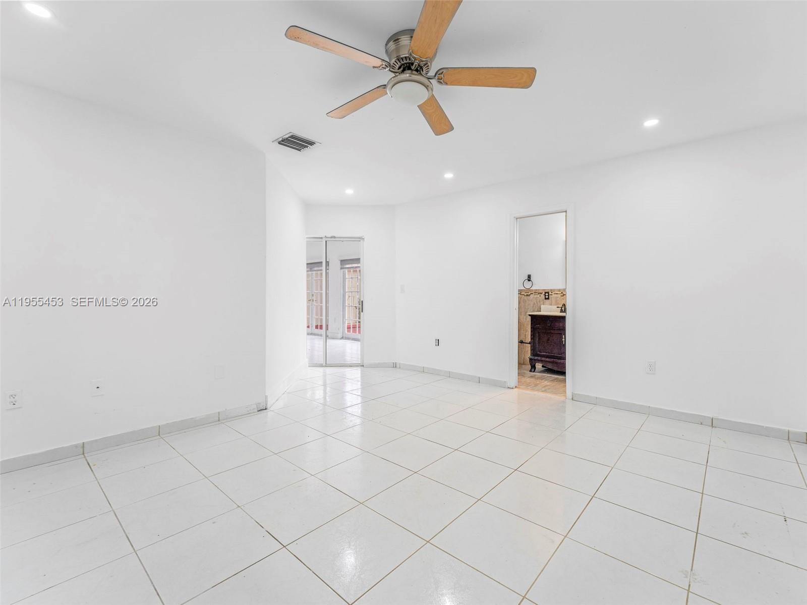 9435 Southwest 156th Place Miami, FL 33196 - Photo 18 of 45 an empty room with chandelier fan and windows