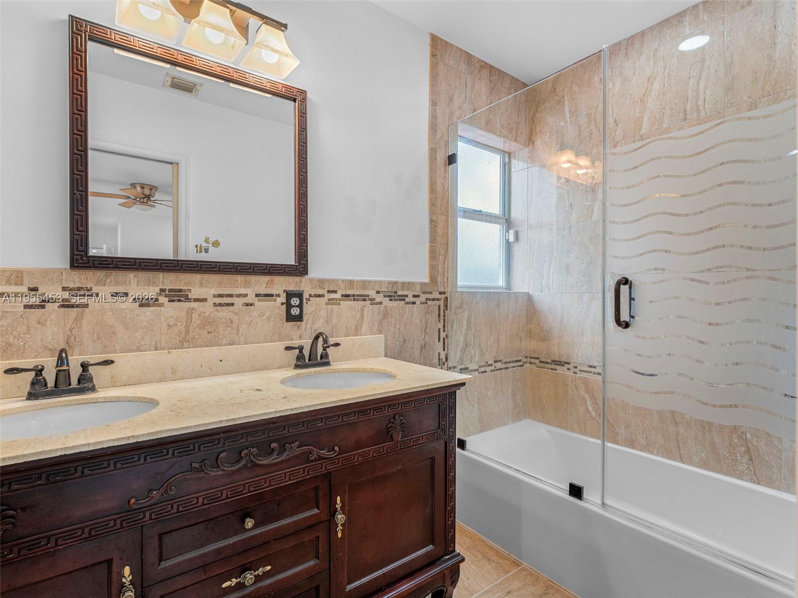 9435 Southwest 156th Place Miami, FL 33196 - Photo 21 of 45 a bathroom with a sink a mirror and a bathtub