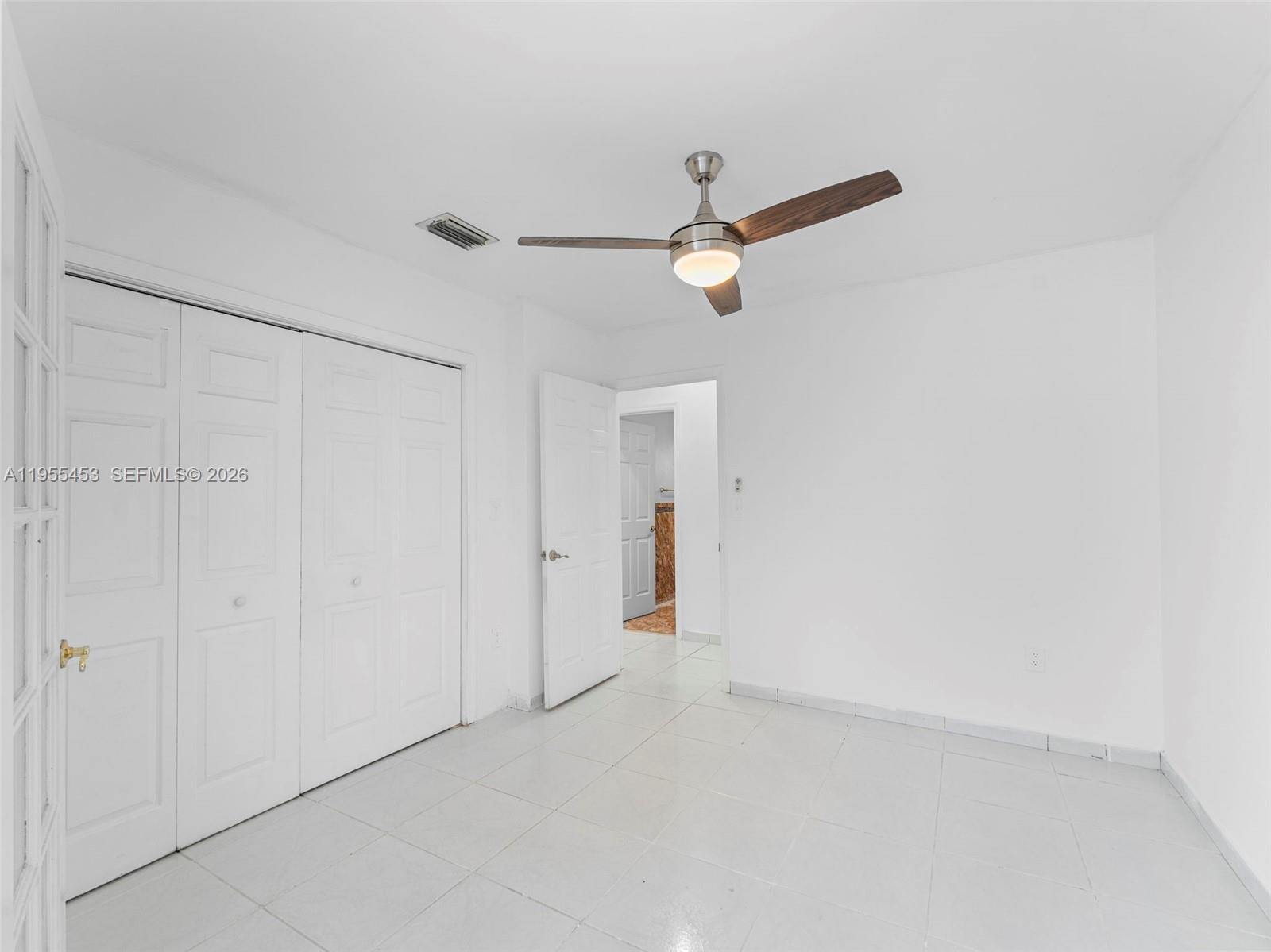 9435 Southwest 156th Place Miami, FL 33196 - Photo 5 of 45 an empty room with a ceiling fan and a window