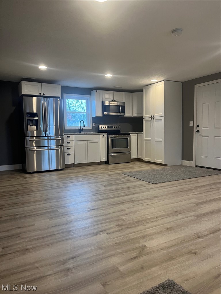 419 Stable Road Lagrange, OH 44050 - Photo 14 of 21 Kitchen featuring stainless steel electric stove, fridge, and light hardwood / wood-style floors