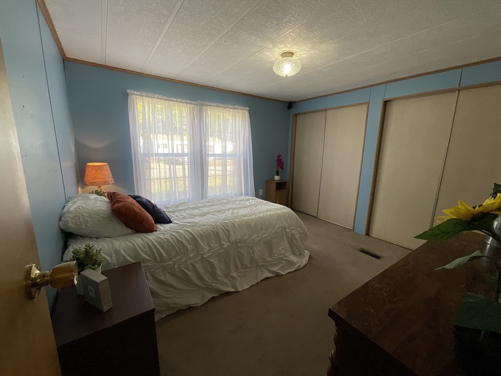 16 Agent Road Raymond, NH 03077 - Photo 11 of 35 a bed sitting in a bedroom next to a window