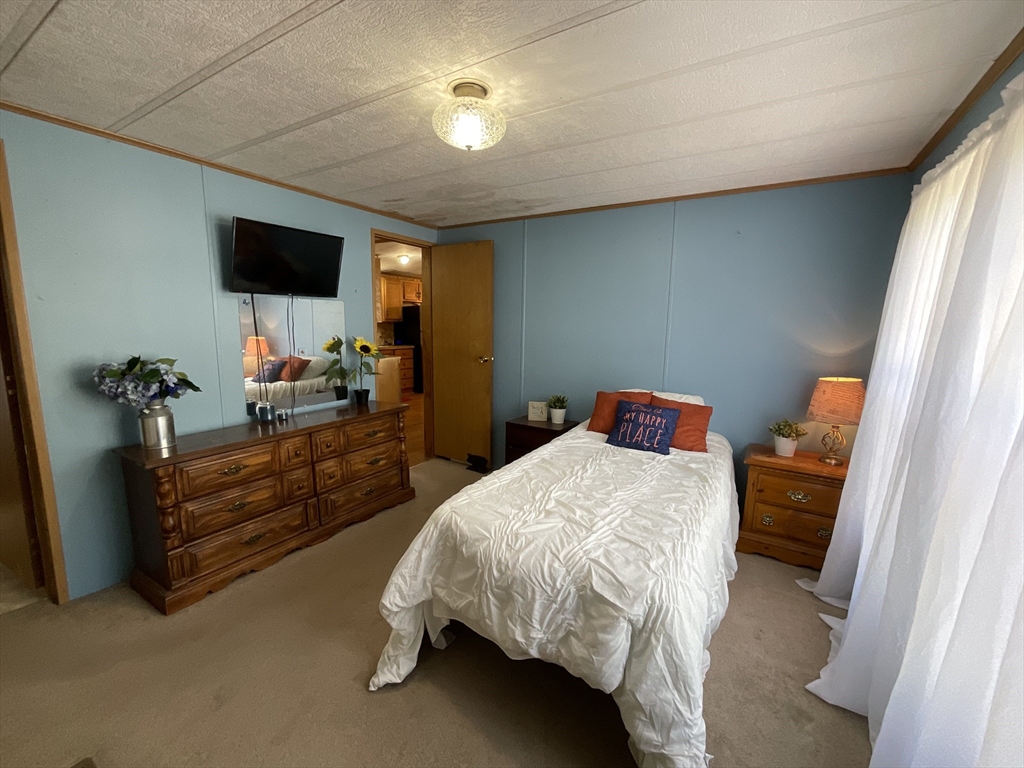 16 Agent Road Raymond, NH 03077 - Photo 13 of 35 a bedroom with a bed and a flat screen tv